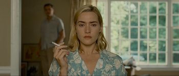 Movie still from “Revolutionary Road” (2008), directed by Sam Mendes – A person holding a cigarette; Close Up shot, Over the shoulder angle