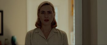 Movie still from “Revolutionary Road” (2008), directed by Sam Mendes – A woman with blonde hair is standing in front of a wall; Close Up shot, Low angle