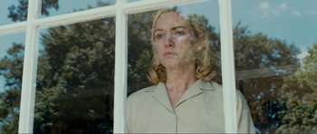 Movie still from “Revolutionary Road” (2008), directed by Sam Mendes – A woman standing in front of a window looking sad; Close Up shot, Low angle