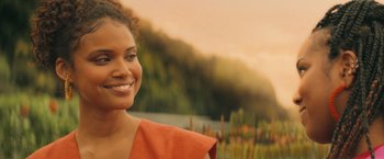 A woman in an orange shirt smiling for the camera