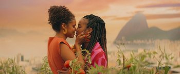 Two young women kissing each other in a field