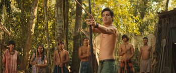 Movie still from “Rich in Love 2” (2023), directed by Bruno Garotti – A group of men standing in the woods holding arrows; Medium shot, Over the shoulder angle