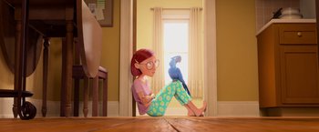 Movie still from “Rio” (2011), directed by Carlos Saldanha – A woman sitting on the ground with a parrot on her lap; Wide shot, Low angle