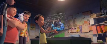 Movie still from “Rio” (2011), directed by Carlos Saldanha – A boy holding a cage with a bunch of stuffed animals in it; Medium shot, High angle