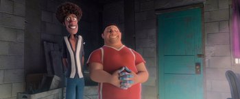 Movie still from “Rio” (2011), directed by Carlos Saldanha – A man in a red and white shirt is standing next to another man in a black and white striped shirt; Medium shot, Over the shoulder angle