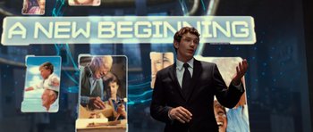 Movie still from “Rise of the Planet of the Apes” (2011), directed by Rupert Wyatt – A man in a suit and tie standing in front of a display; Medium shot, Over the shoulder angle