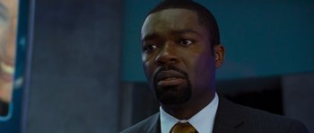 Movie still from “Rise of the Planet of the Apes” (2011), directed by Rupert Wyatt – A person wearing a suit and tie; Close Up shot, Over the shoulder angle