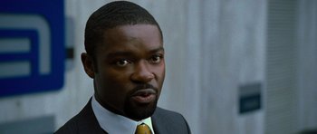 Movie still from “Rise of the Planet of the Apes” (2011), directed by Rupert Wyatt – A person wearing a suit and tie; Close Up shot, Over the shoulder angle