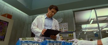 Movie still from “Rise of the Planet of the Apes” (2011), directed by Rupert Wyatt – A man in a lab coat writing on a clipboard; Medium shot, Low angle