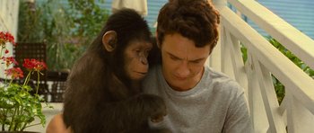 Movie still from “Rise of the Planet of the Apes” (2011), directed by Rupert Wyatt – A young man holding onto a baby monkey; Close Up shot, Low angle
