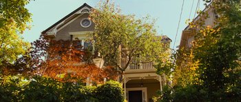 Movie still from “Rise of the Planet of the Apes” (2011), directed by Rupert Wyatt – A large tree in front of a house with a clock on it; Wide shot, Low angle