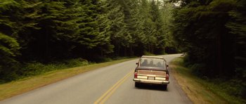 Movie still from “Rise of the Planet of the Apes” (2011), directed by Rupert Wyatt – Two people in the back of a truck driving down a road; Wide shot, High angle