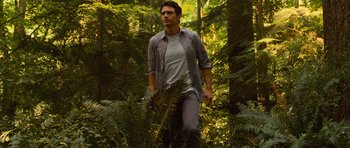 Movie still from “Rise of the Planet of the Apes” (2011), directed by Rupert Wyatt – A man walking through the woods holding a plant; Medium shot, Low angle