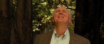 Movie still from “Rise of the Planet of the Apes” (2011), directed by Rupert Wyatt – An older man looking up into the sky in a wooded area; Close Up shot, Low angle