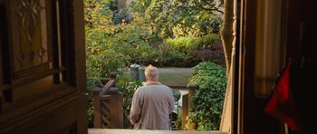 Movie still from “Rise of the Planet of the Apes” (2011), directed by Rupert Wyatt – An older man standing on a deck looking at a garden; Wide shot, High angle