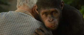 Movie still from “Rise of the Planet of the Apes” (2011), directed by Rupert Wyatt – An old man hugging a monkey with green eyes; Close Up shot, Over the shoulder angle