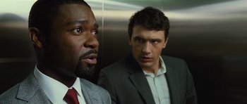 Movie still from “Rise of the Planet of the Apes” (2011), directed by Rupert Wyatt – Two men in business suits looking at each other; Close Up shot, Low angle