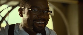 Movie still from “Rise of the Planet of the Apes” (2011), directed by Rupert Wyatt – A person wearing glasses and smiling; Close Up shot, Low angle