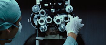 Movie still from “Rise of the Planet of the Apes” (2011), directed by Rupert Wyatt – An eye doctor examining a patient's eyes in an ophthalmologist's office; Extreme Close Up shot, Over the shoulder angle