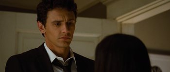 Movie still from “Rise of the Planet of the Apes” (2011), directed by Rupert Wyatt – A person wearing a suit and tie; Close Up shot, Over the shoulder angle