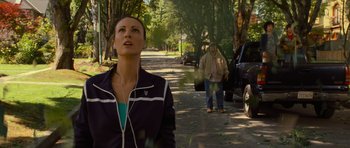 Movie still from “Rise of the Planet of the Apes” (2011), directed by Rupert Wyatt – A woman is walking down the street while a man is walking down the street; Medium shot, Low angle
