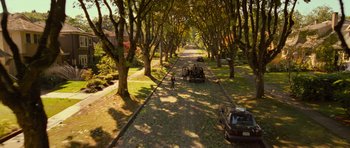 Movie still from “Rise of the Planet of the Apes” (2011), directed by Rupert Wyatt – An aerial view of a road with cars parked on the side of the road; Extreme Wide shot, High angle