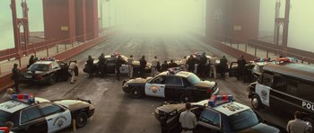 Movie still from “Rise of the Planet of the Apes” (2011), directed by Rupert Wyatt – A group of police officers standing on the side of a road; Extreme Wide shot, High angle