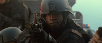 Movie still from “Rise of the Planet of the Apes” (2011), directed by Rupert Wyatt – A man in a helmet is holding a gun; Close Up shot, Low angle
