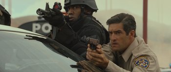 Movie still from “Rise of the Planet of the Apes” (2011), directed by Rupert Wyatt – Two men in uniform are holding guns in a car; Close Up shot, Over the shoulder angle