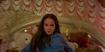 Movie still from “Roald Dahl's Matilda the Musical” (2022), directed by Matthew Warchus – A young girl is standing in a room with stuffed animals; Close Up shot, High angle