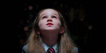 Movie still from “Roald Dahl's Matilda the Musical” (2022), directed by Matthew Warchus – A girl in a suit and tie looking up at the sky; Close Up shot, Low angle