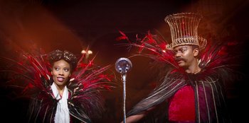 Movie still from “Roald Dahl's Matilda the Musical” (2022), directed by Matthew Warchus – A man and a woman in red and black costumes; Medium shot, Over the shoulder angle