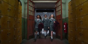 Movie still from “Roald Dahl's Matilda the Musical” (2022), directed by Matthew Warchus – A group of young people walking down a hall way; Wide shot, Low angle