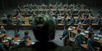 Movie still from “Roald Dahl's Matilda the Musical” (2022), directed by Matthew Warchus – A group of people sitting at tables with plates of food; Wide shot, High angle