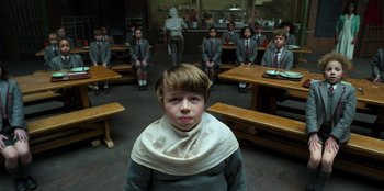 Movie still from “Roald Dahl's Matilda the Musical” (2022), directed by Matthew Warchus – A group of school children sitting in a circle in a classroom; Medium shot, High angle