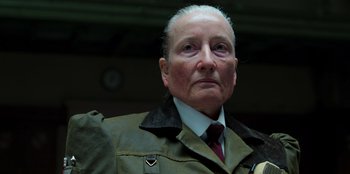 Movie still from “Roald Dahl's Matilda the Musical” (2022), directed by Matthew Warchus – An older man wearing a jacket and a tie; Close Up shot, Over the shoulder angle