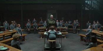 Movie still from “Roald Dahl's Matilda the Musical” (2022), directed by Matthew Warchus – A group of people sitting in a room; Wide shot, High angle