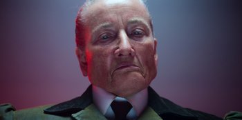 Movie still from “Roald Dahl's Matilda the Musical” (2022), directed by Matthew Warchus – An older man with a frowning look on his face; Close Up shot, Low angle