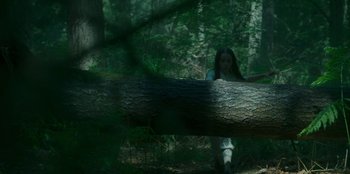 Movie still from “Roald Dahl's Matilda the Musical” (2022), directed by Matthew Warchus – A woman in a white dress leaning against a tree; Wide shot, Low angle