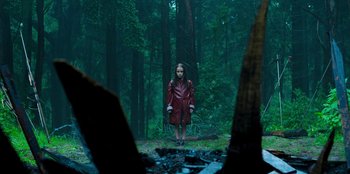 Movie still from “Roald Dahl's Matilda the Musical” (2022), directed by Matthew Warchus – A woman in a red coat standing in the middle of a forest; Wide shot, Low angle
