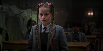 Movie still from “Roald Dahl's Matilda the Musical” (2022), directed by Matthew Warchus – A young girl with pigtails in a school uniform; Close Up shot, Low angle