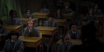 Movie still from “Roald Dahl's Matilda the Musical” (2022), directed by Matthew Warchus – A group of children sitting at their desks in a classroom; Wide shot, High angle