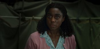 Movie still from “Roald Dahl's Matilda the Musical” (2022), directed by Matthew Warchus – A young woman with curly black hair wearing a pink jacket; Close Up shot, Over the shoulder angle