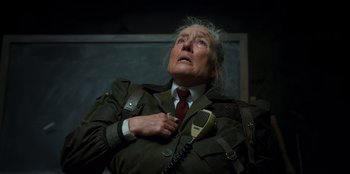 Movie still from “Roald Dahl's Matilda the Musical” (2022), directed by Matthew Warchus – An old man in a green jacket holding a phone; Close Up shot, Low angle