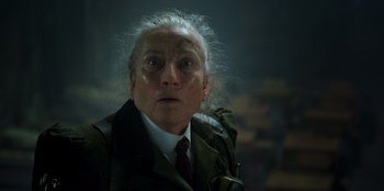 Movie still from “Roald Dahl's Matilda the Musical” (2022), directed by Matthew Warchus – An old man with a white beard wearing a jacket and tie; Close Up shot, Over the shoulder angle