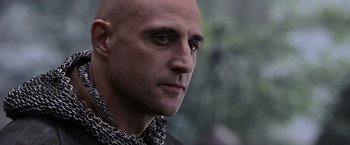 Movie still from “Robin Hood” (2010), directed by Ridley Scott – A man with a bald head wearing chains; Close Up shot, Low angle