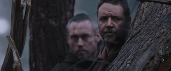 Movie still from “Robin Hood” (2010), directed by Ridley Scott – Two men standing next to each other near a tree; Close Up shot, Low angle