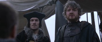 Movie still from “Robin Hood” (2010), directed by Ridley Scott – Two men standing next to each other in medieval garb; Close Up shot, Low angle