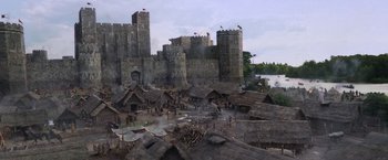 Movie still from “Robin Hood” (2010), directed by Ridley Scott – An image of a medieval town with a castle in the background; Extreme Wide shot, High angle