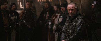 Movie still from “Robin Hood” (2010), directed by Ridley Scott – A group of men in medieval garb standing next to each other; Close Up shot, Over the shoulder angle